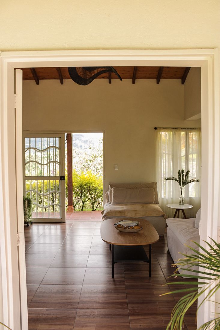 Sala de Casa Taná abierta al jardín y la montaña